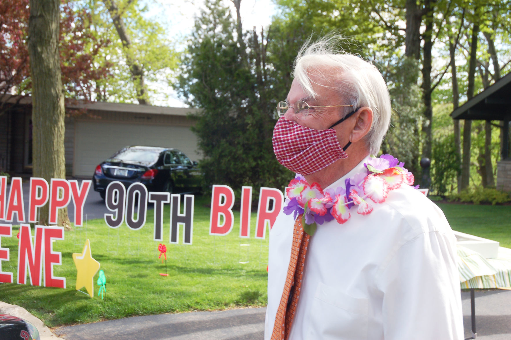 Gene Haseley watches cars arrive for birthday parade outside his house